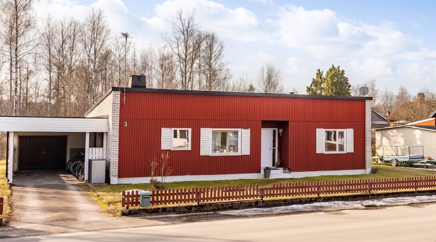 Det röda trähuset på Mellangatan 3 i Emmaboda med carport och rött spjälstaket